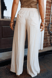 Person wearing beige wide-leg pants with a blurred background