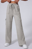 Person in light gray wide-leg cargo sweatpants with drawstring waist and pockets.
