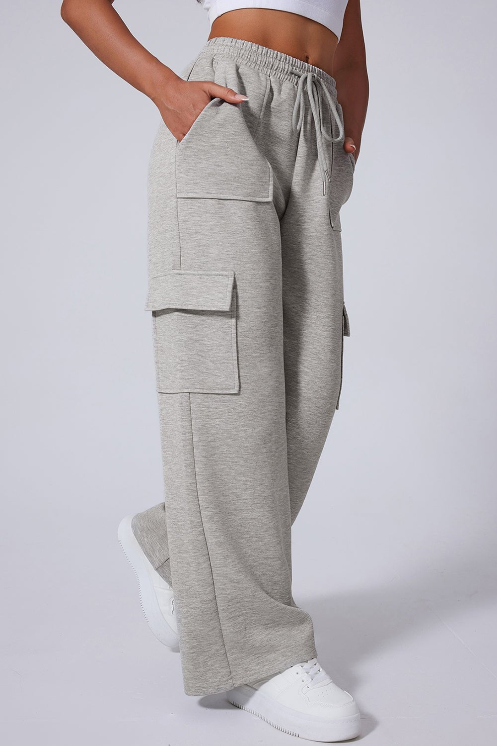 Gray cargo pants worn by a person on a white background