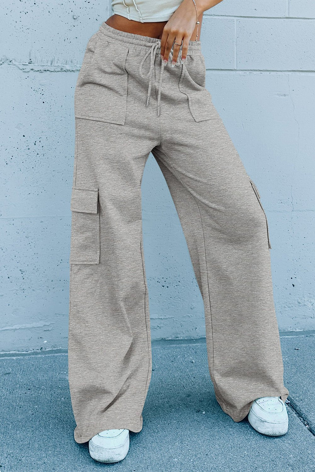 Person wearing beige cargo pants against a light blue wall.