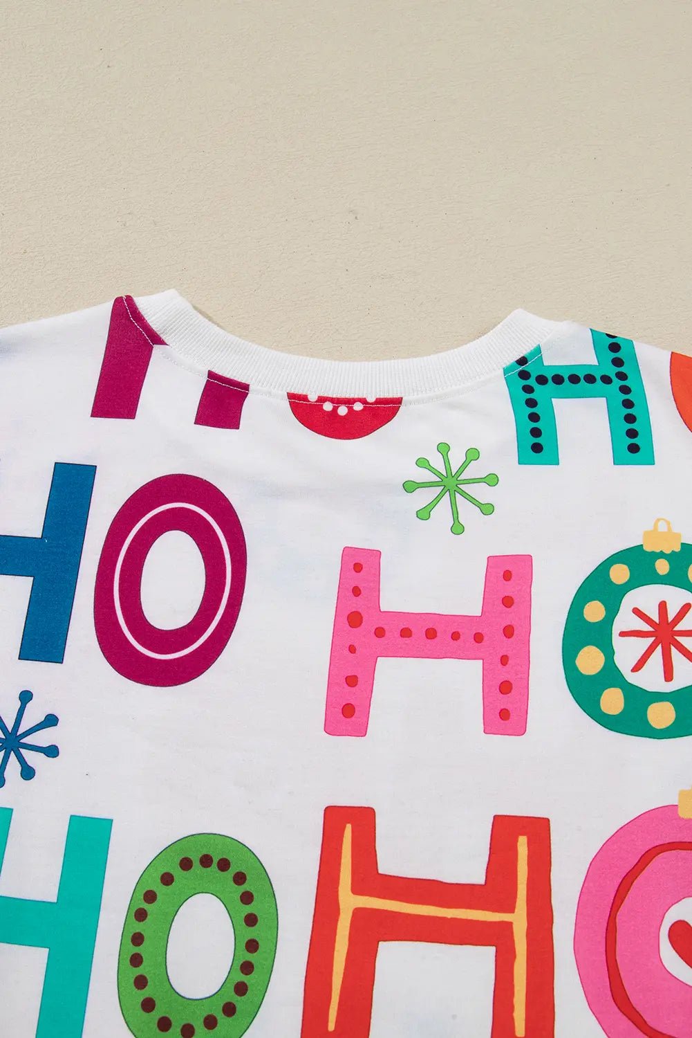 White shirt with colorful HO HO HO text and festive Christmas graphics.