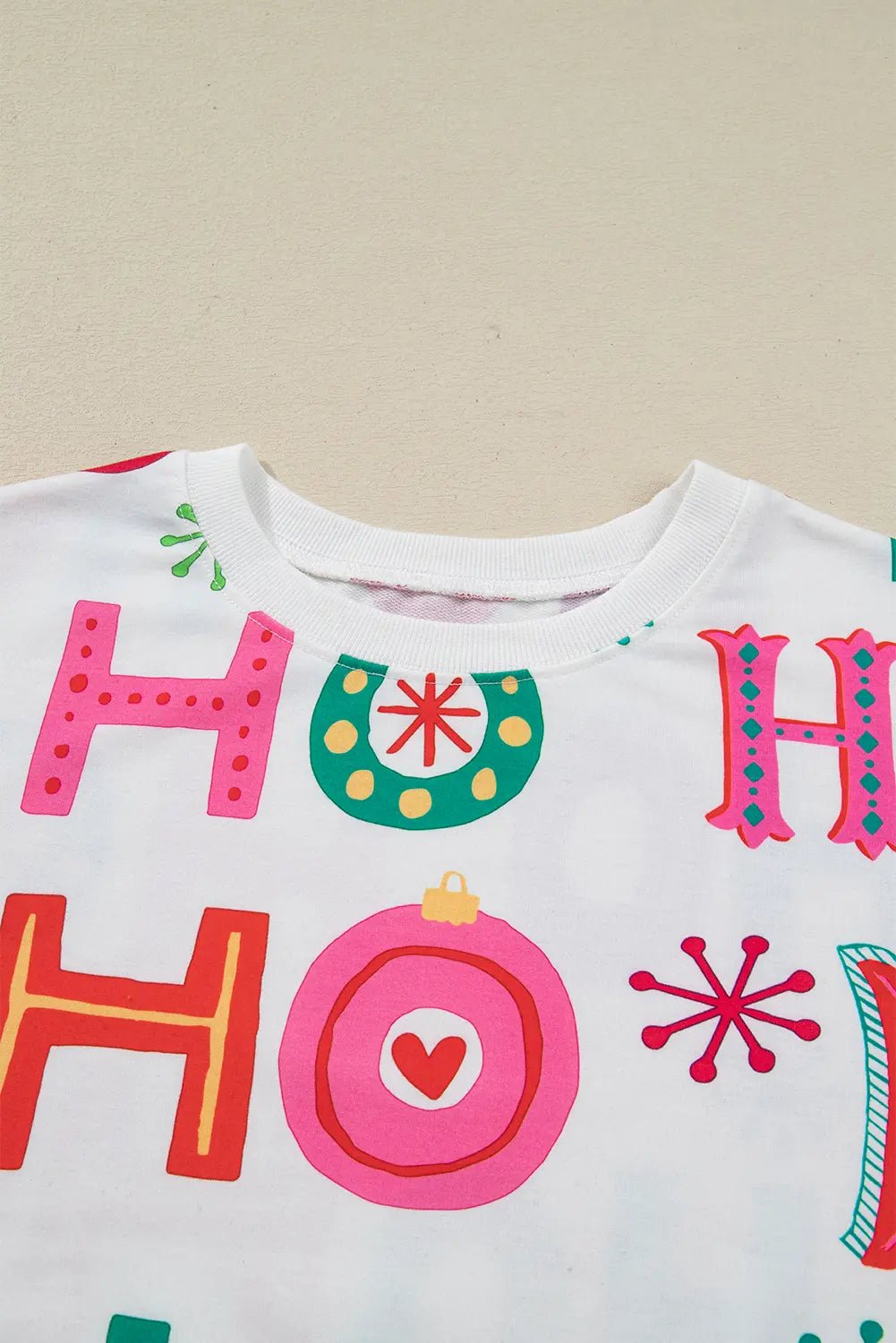 Close-up of a white sweatshirt with colorful HO HO HO Christmas print.