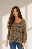 Woman wearing a patterned sweater against a neutral background