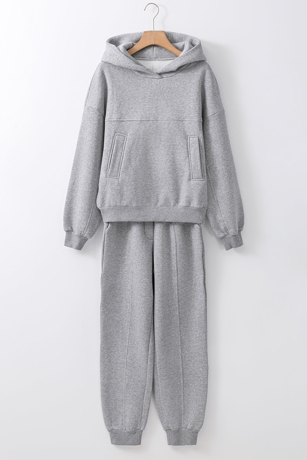 Gray tracksuit on a hanger against a white background