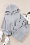 Gray hoodie and pants set with white sneakers on a beige background