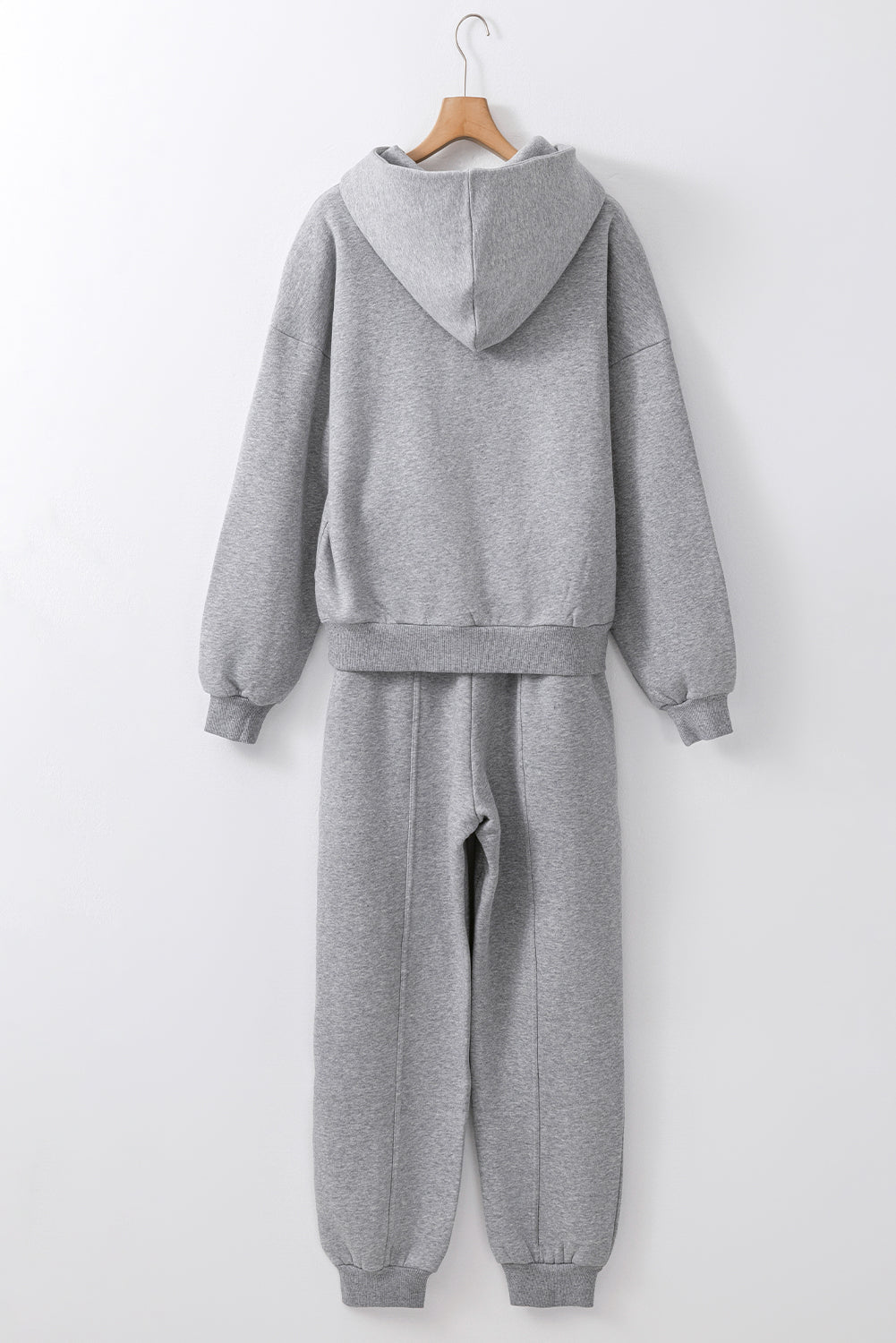 Gray tracksuit on a hanger against a white background