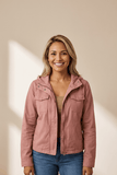 Woman wearing a pink jacket against a beige background