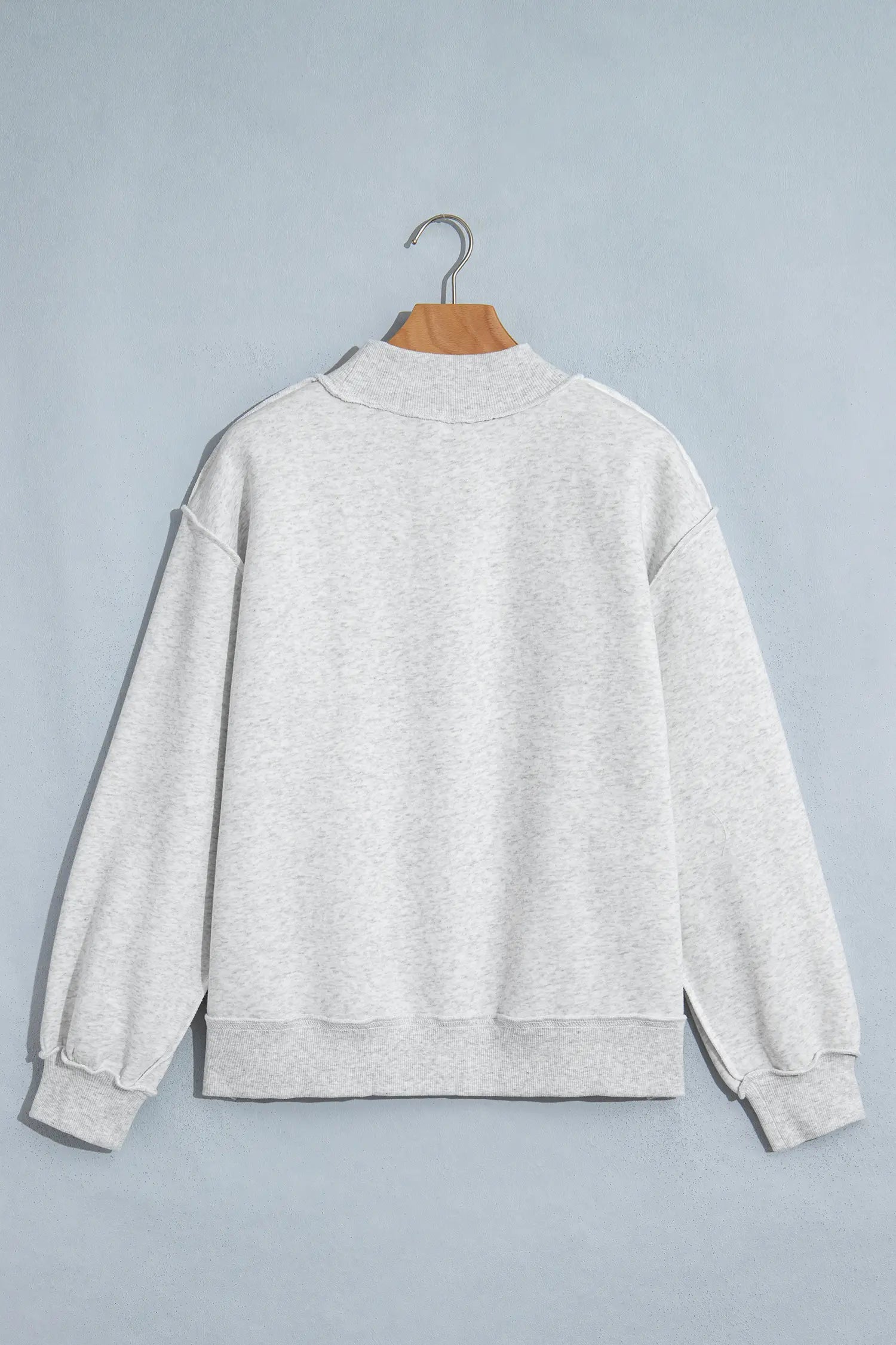 Gray oversized mock neck sweatshirt on a hanger, back view