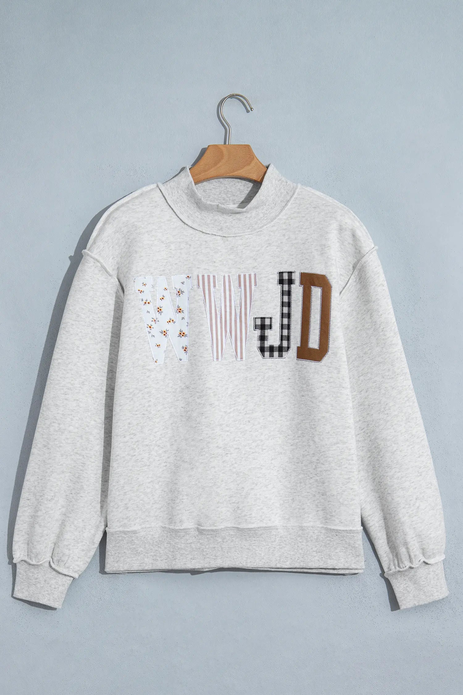 Gray WWJD patchwork letter mock neck sweatshirt on a hanger, front view
