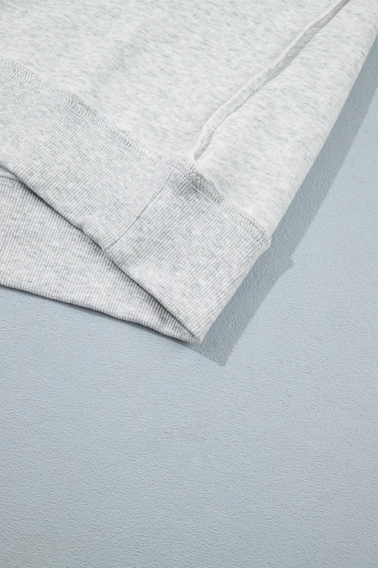 Ribbed hem band with exposed seam on gray sweatshirt