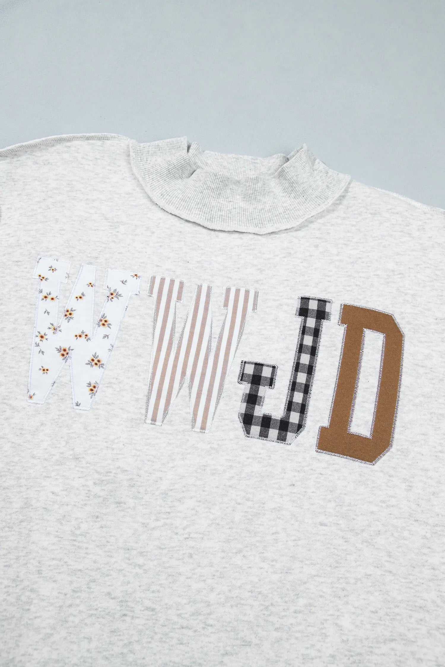 Floral, stripe, gingham and solid WWJD patch letters on gray sweatshirt