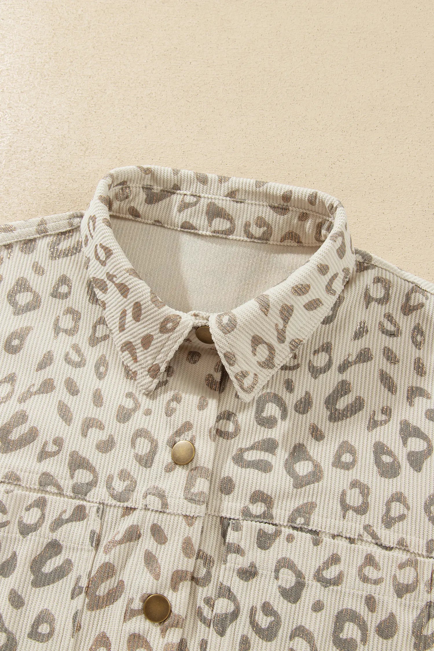 Shirt collar and gold-tone snaps on khaki leopard corduroy jacket