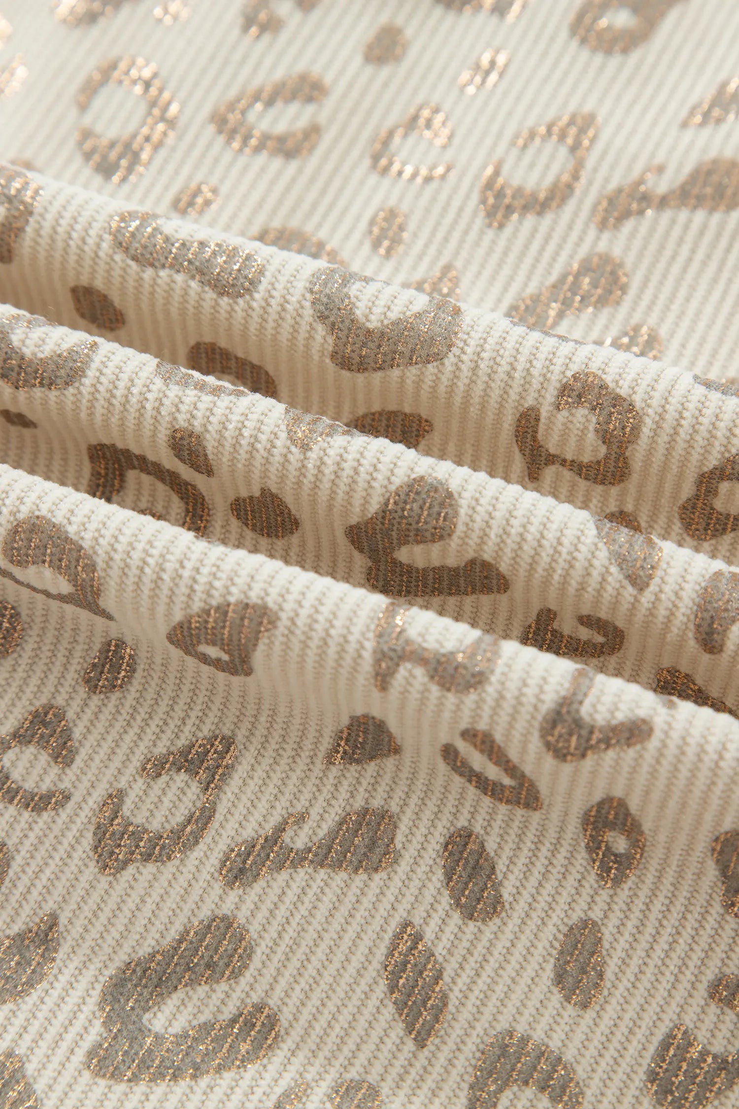 Close-up of fine wale corduroy with khaki leopard print and shimmer