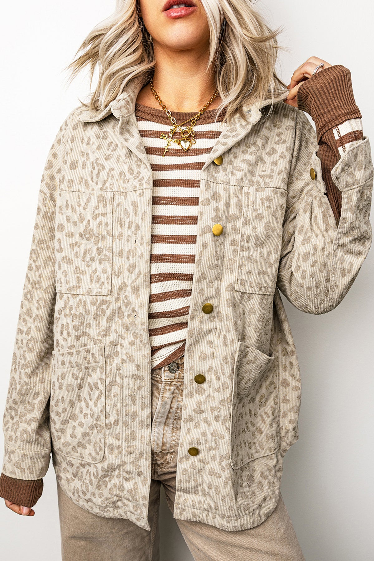 Woman in khaki leopard corduroy snap front shirt jacket over a striped tee, front view