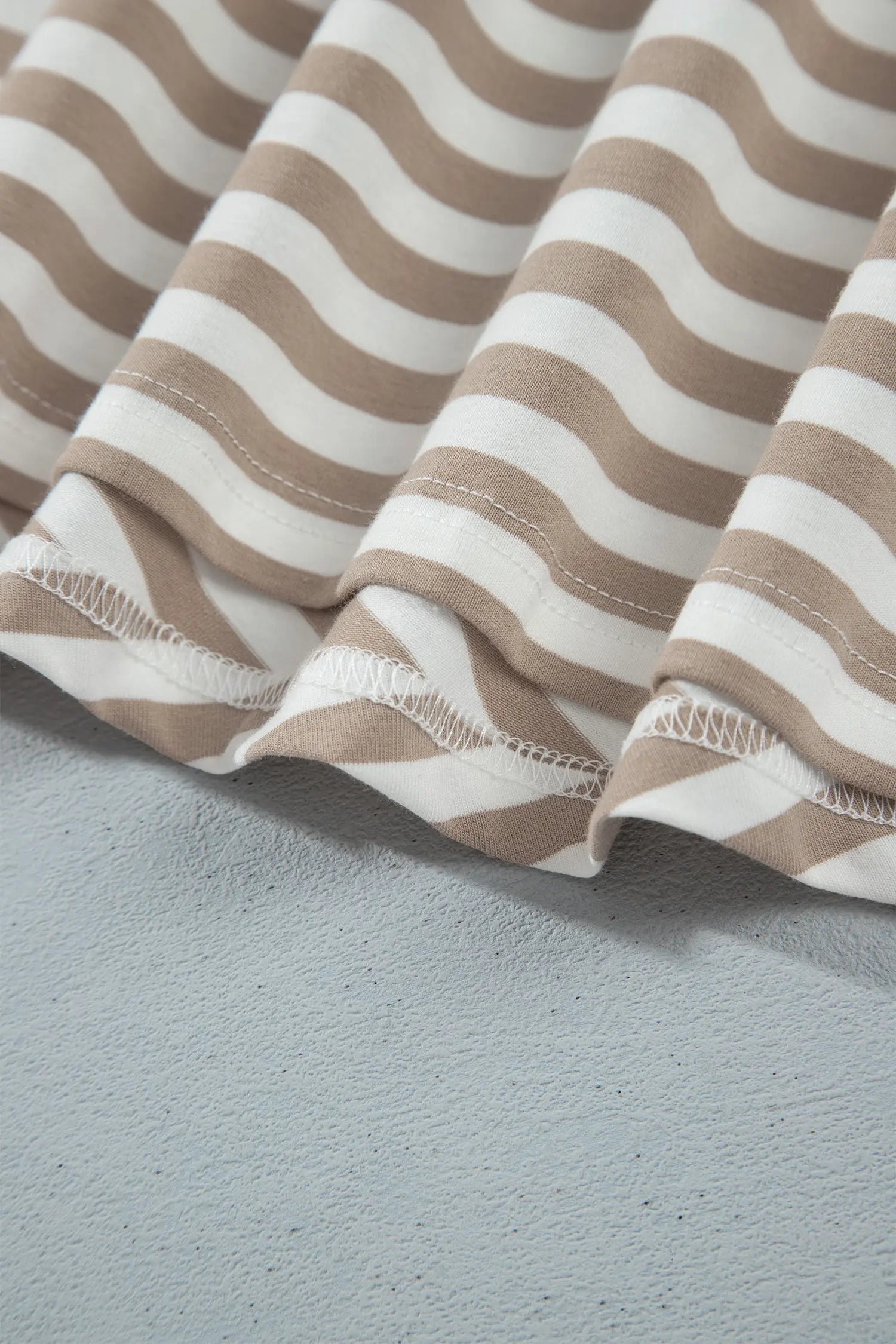 Hem detail on khaki and white striped midi dress