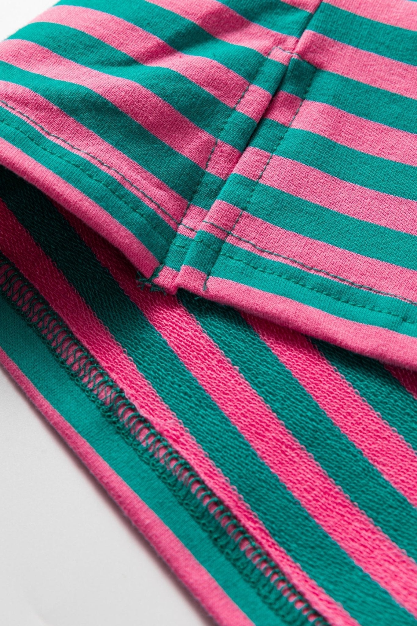 Close-up of pink and green striped fabric with a visible zipper.