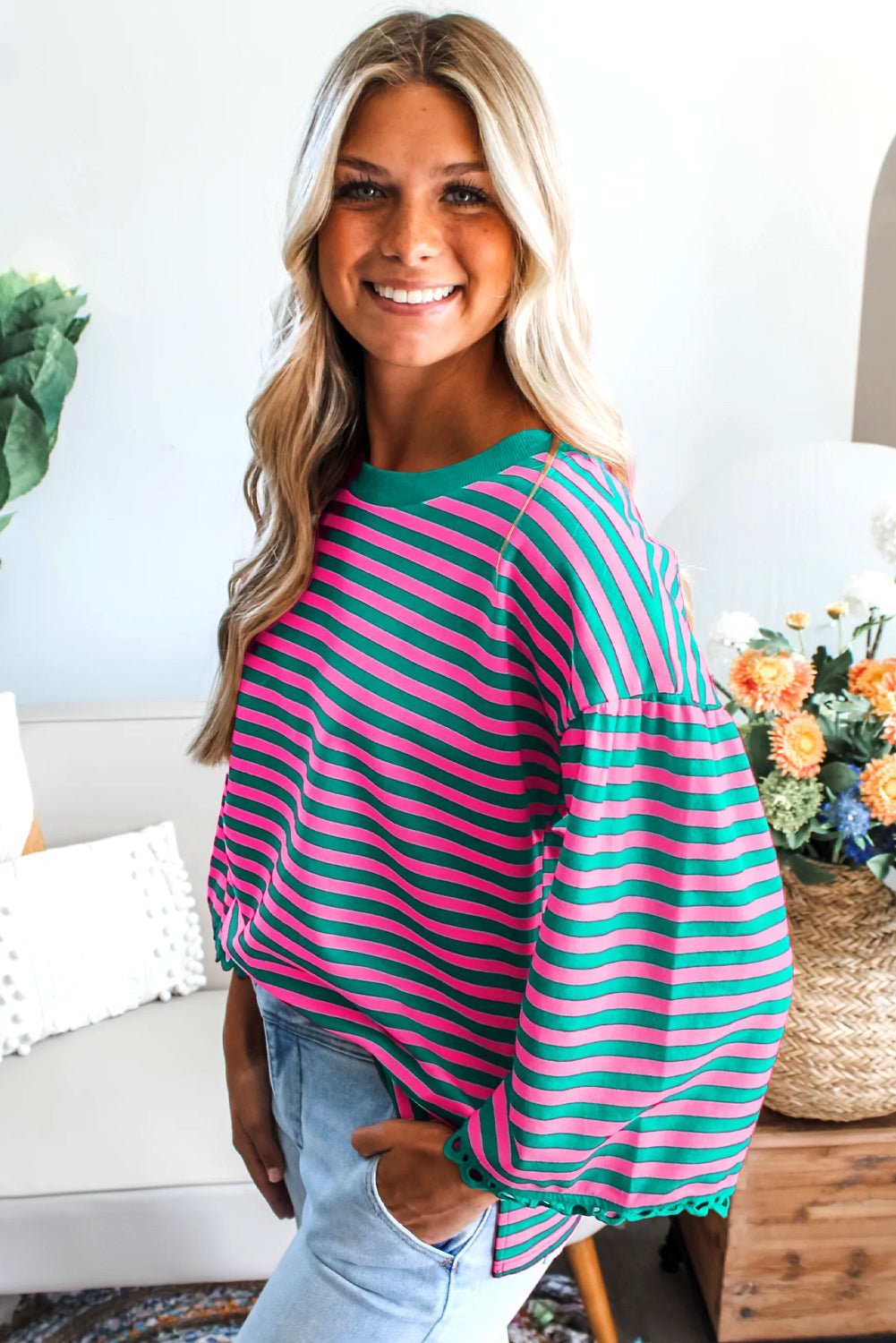 Woman wearing a pink and green striped sweater in a home setting