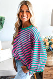 Woman wearing a pink and green striped sweater in a home setting