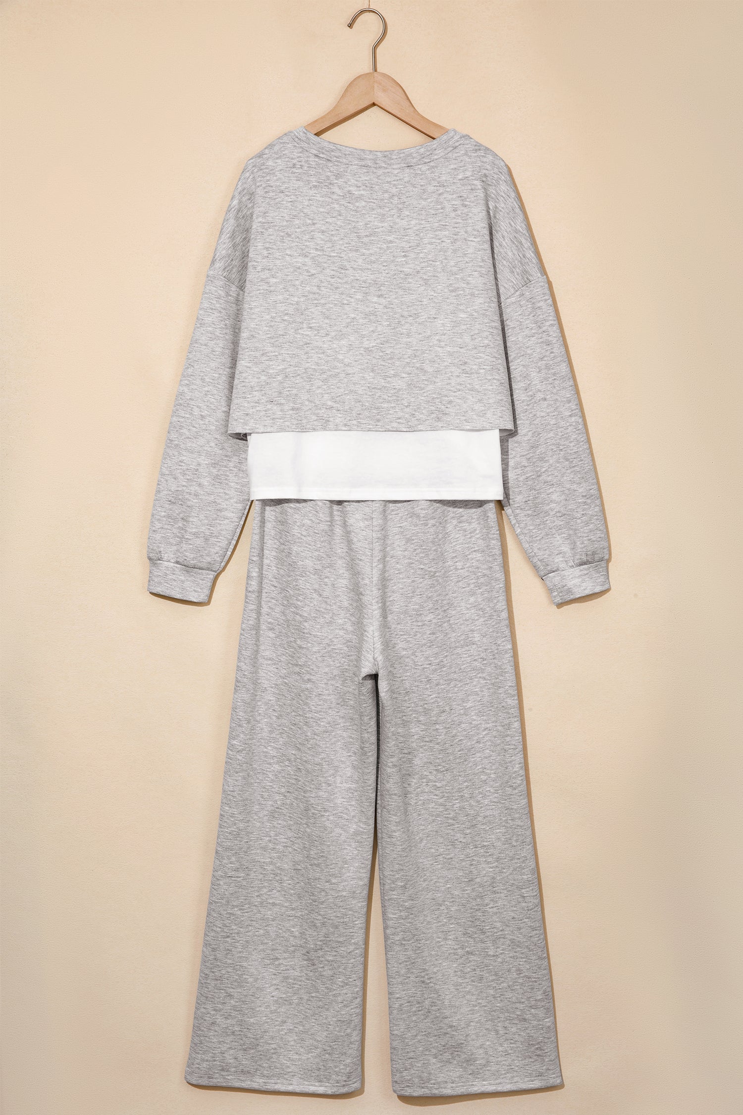 Gray crop top and wide leg pants set on a hanger, back view