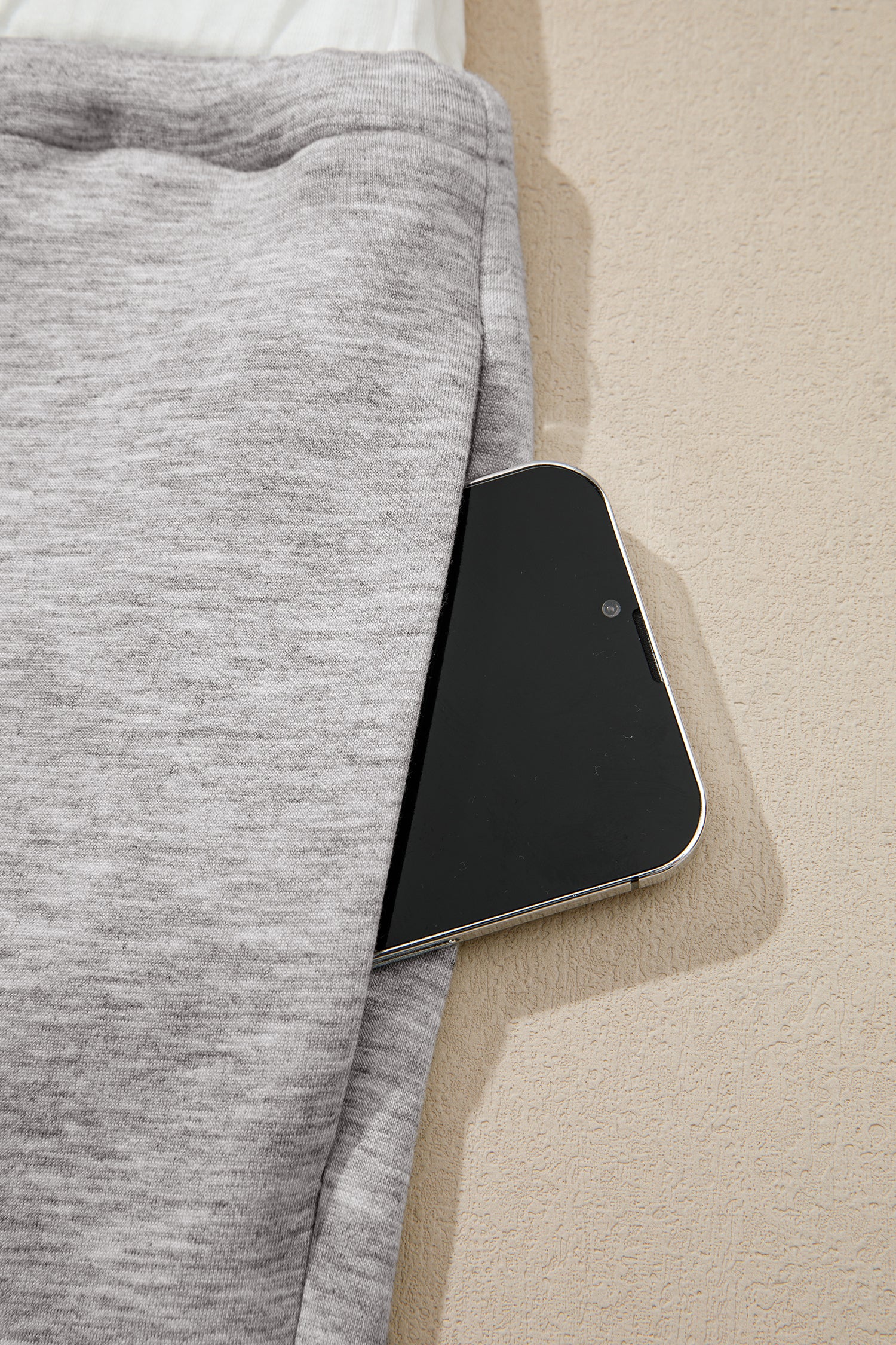 Gray wide leg pants side pocket holding a phone