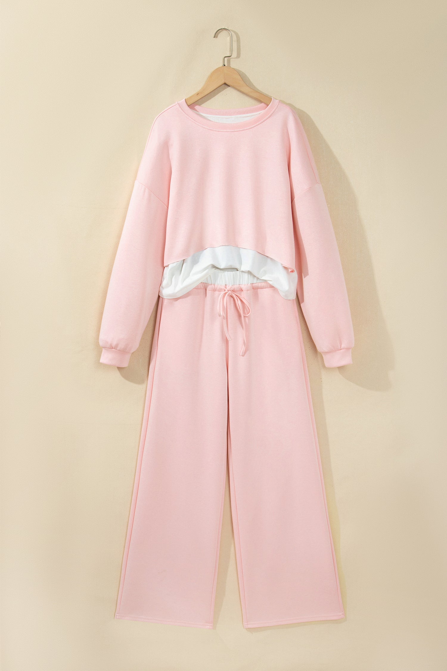Pink crop top and drawstring wide leg pants set on a hanger, front view