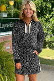 Woman wearing a leopard print dress with a zipper in front, standing outdoors.