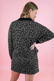 Person wearing a leopard print dress against a pink background
