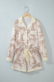 Two-piece pajama set with cream collar and tie belt on wooden hanger.