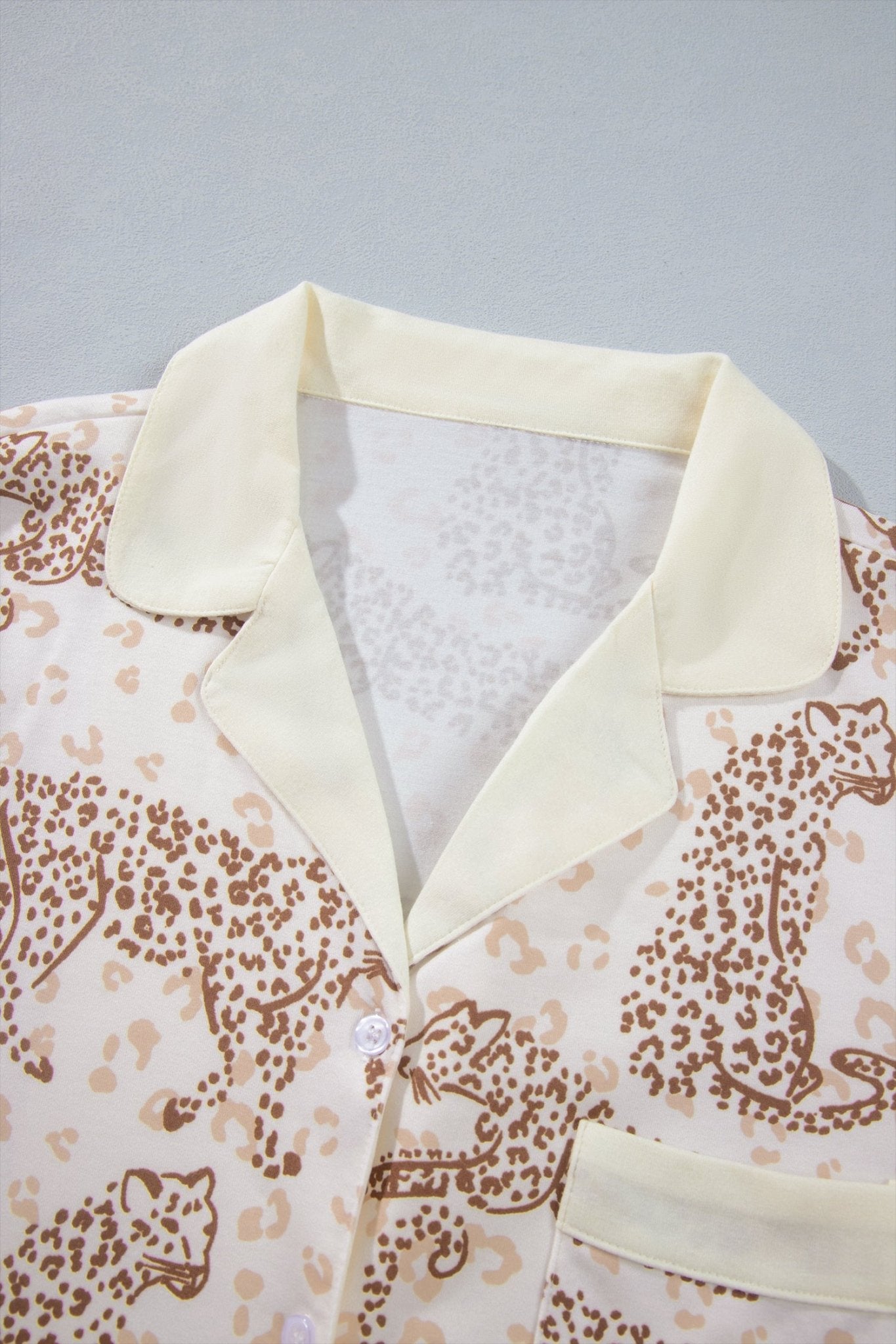 Close-up of cream collared shirt with brown leopard and cheetah print.