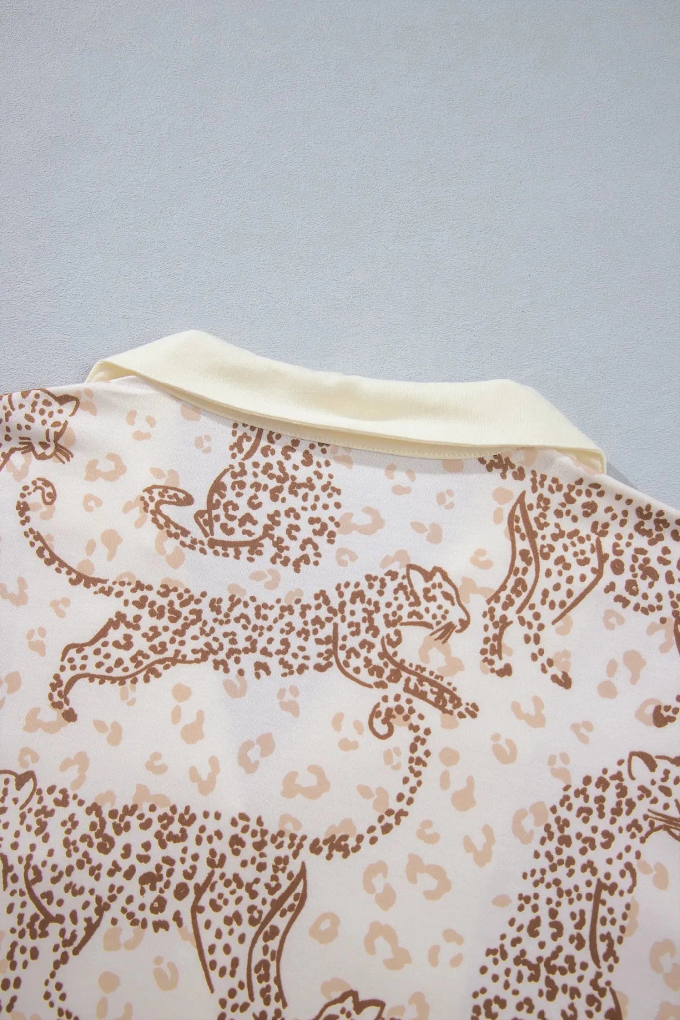 Close-up of cream shirt with brown leopard print and solid collar