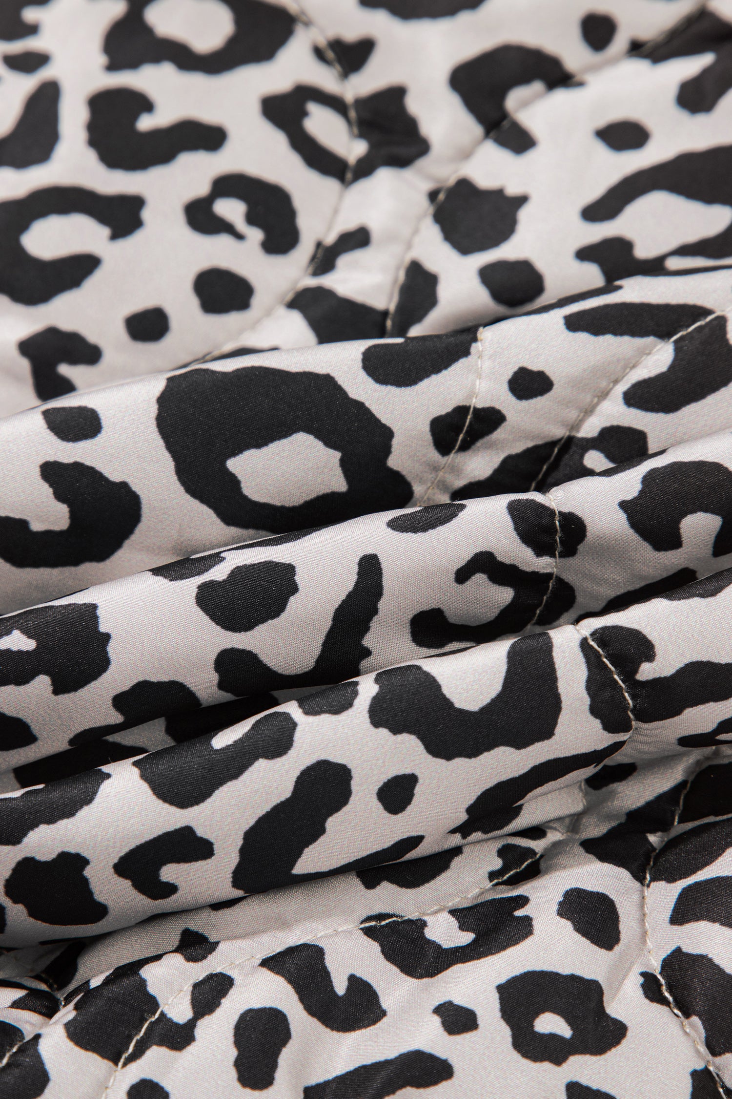 Close-up of khaki and black leopard print quilted fabric