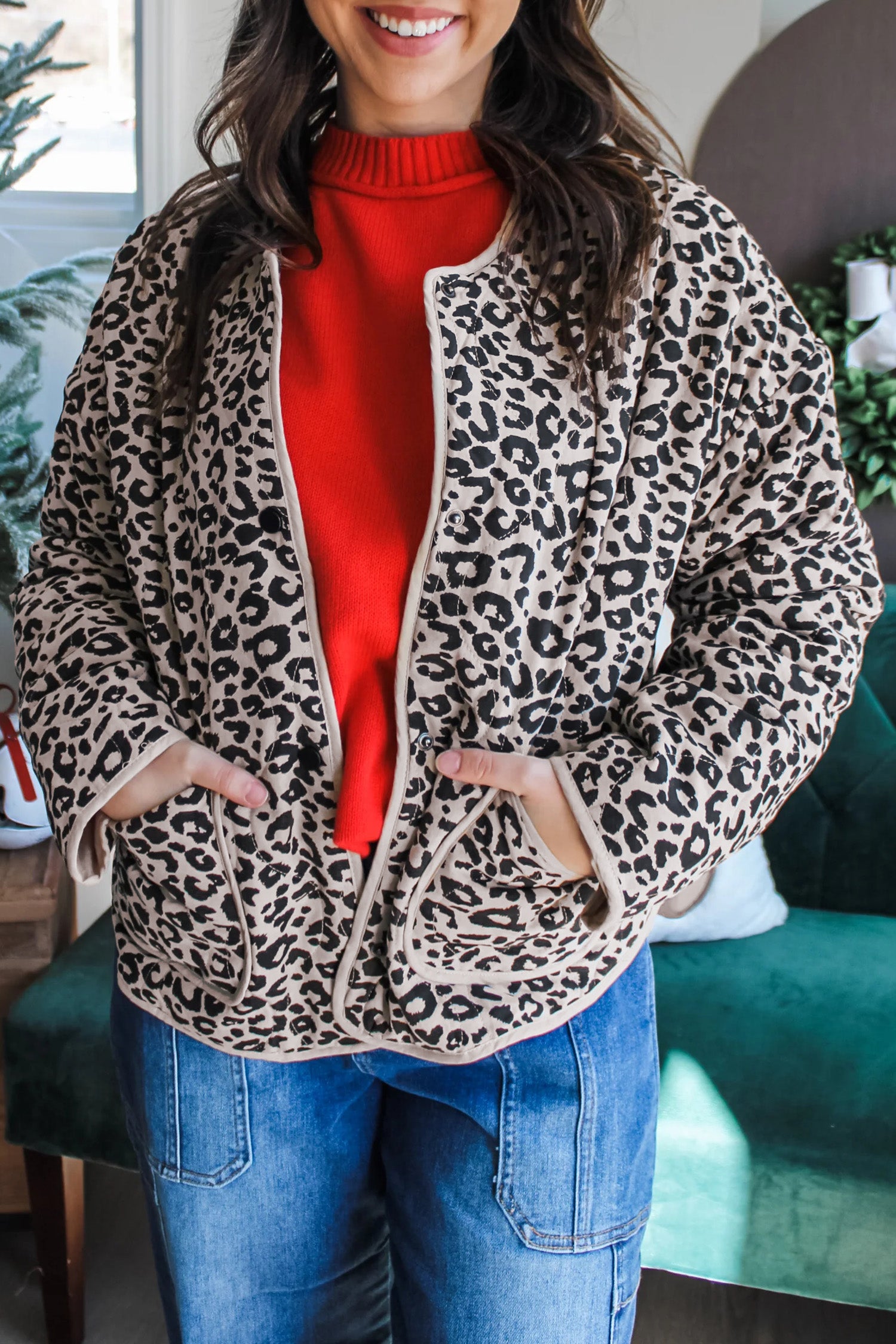 Women's khaki leopard print quilted jacket with red sweater and jeans, front view