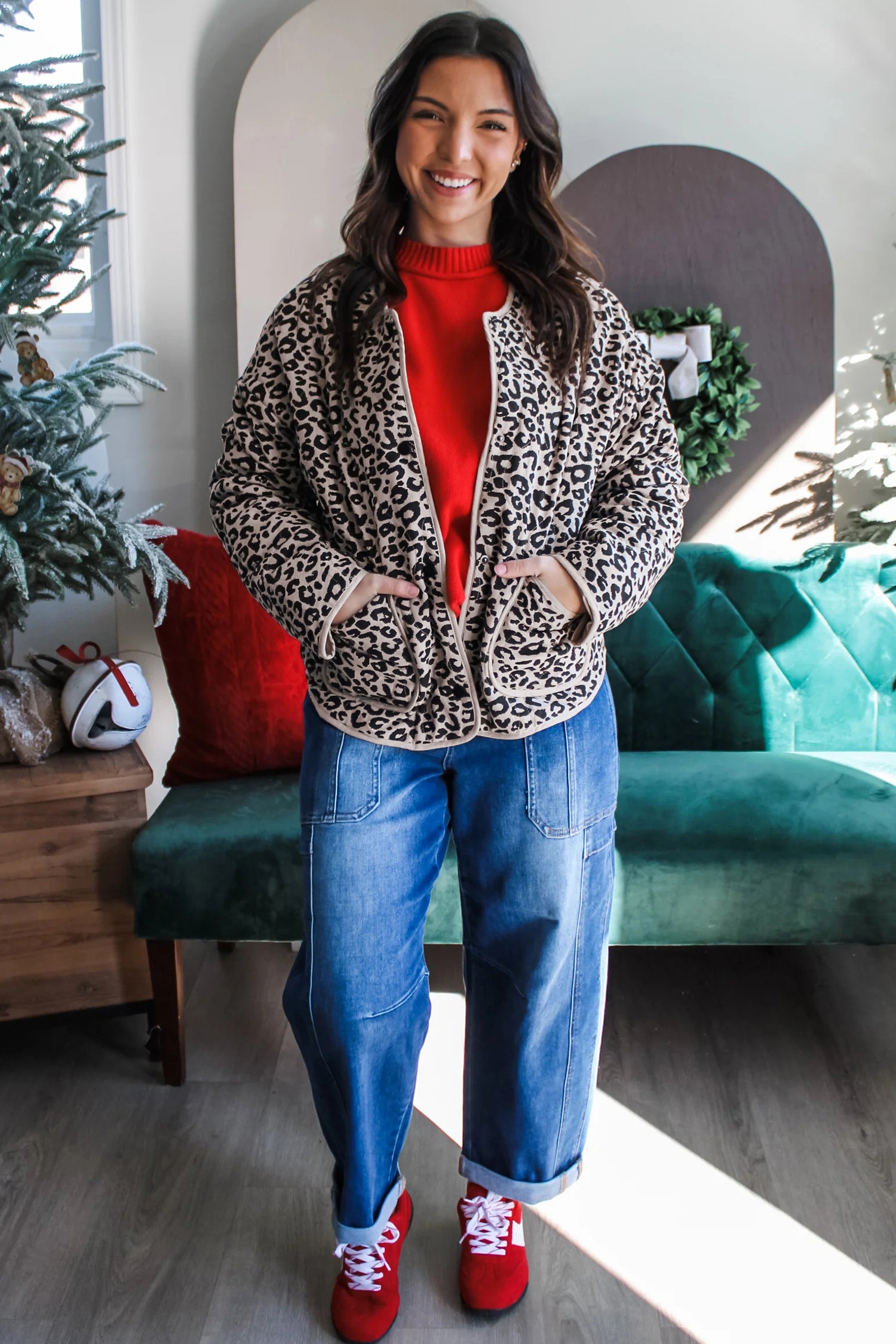 Leopard print quilted jacket with red sweater, jeans and red sneakers, full length
