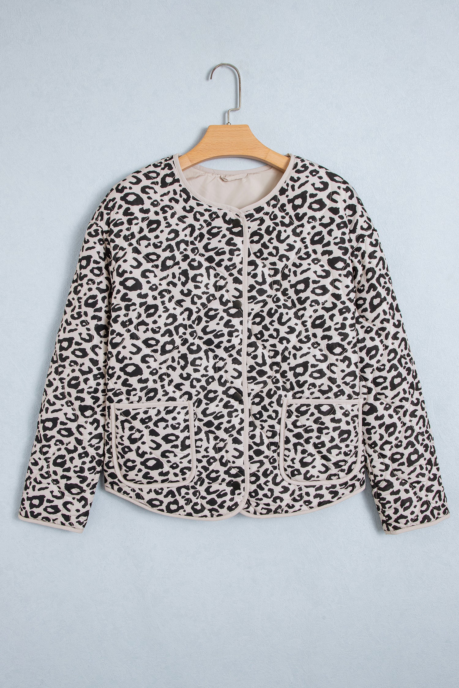 Khaki leopard quilted jacket with snap front and patch pockets on a hanger, front view