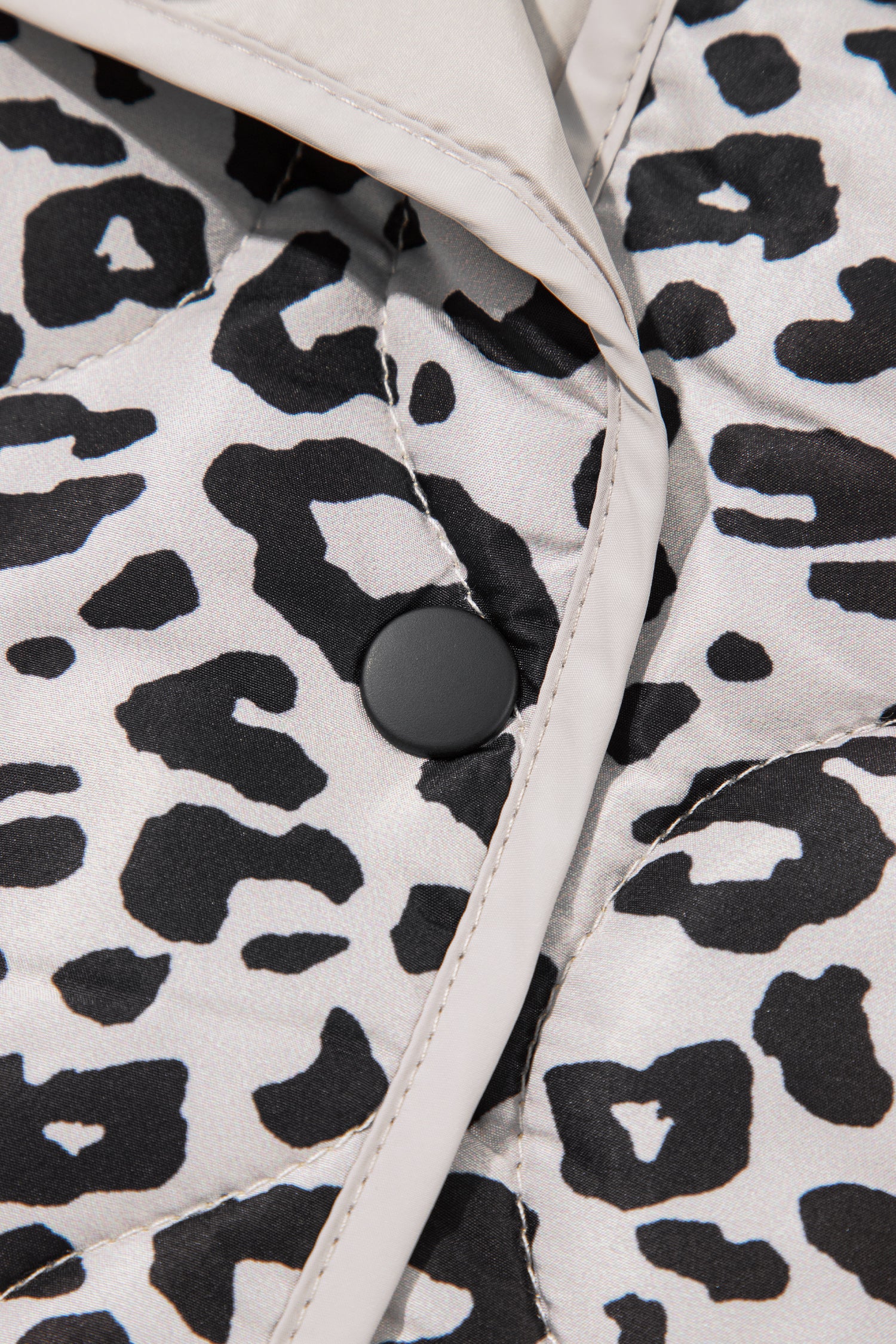Leopard quilted jacket black snap button and binding trim close-up