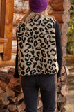 Person wearing a leopard print vest and purple beanie standing in front of stacked logs.