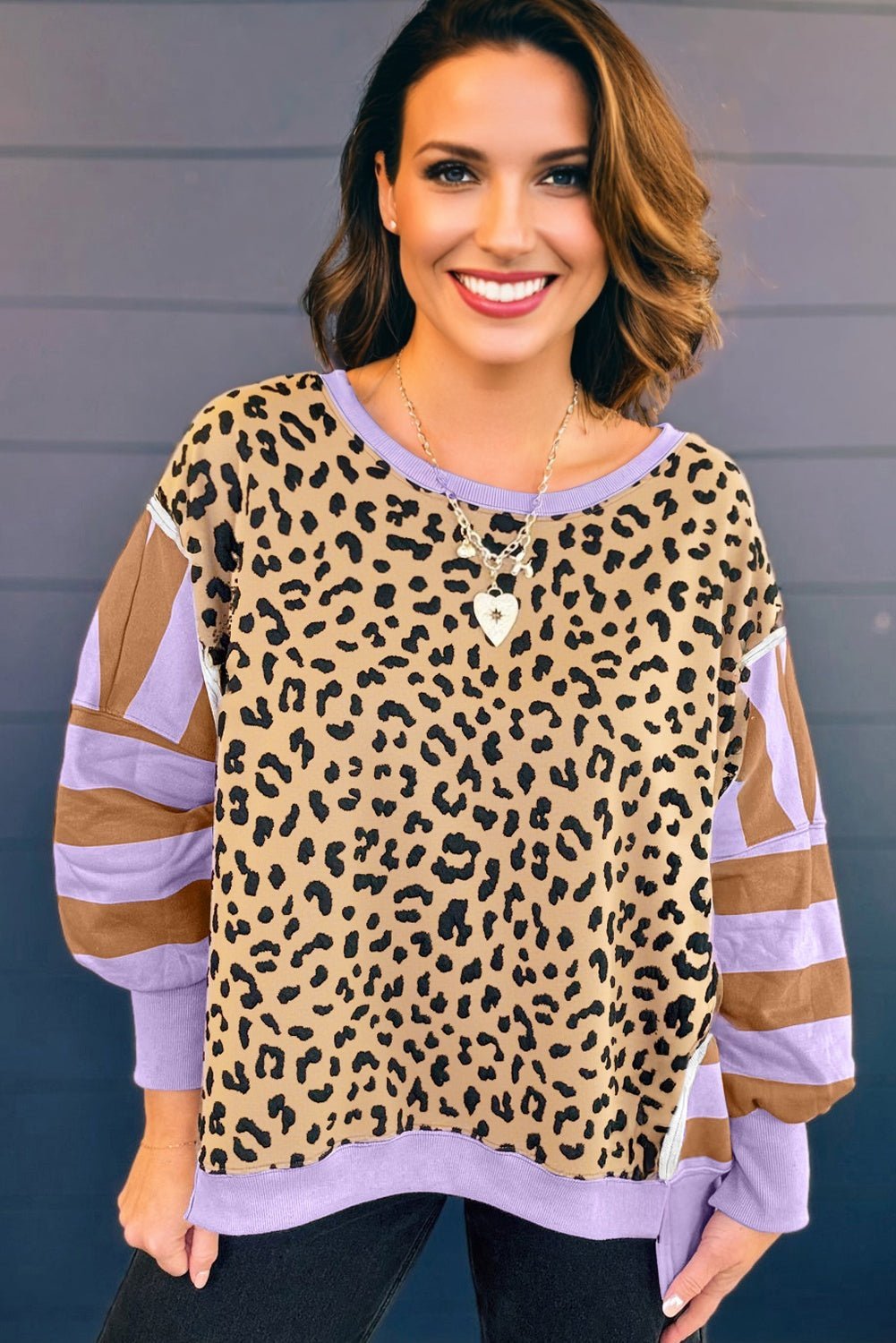 Woman wearing a leopard print and sheer long-sleeve top against a gray background