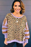 Woman wearing a leopard print and sheer long-sleeve top against a gray background