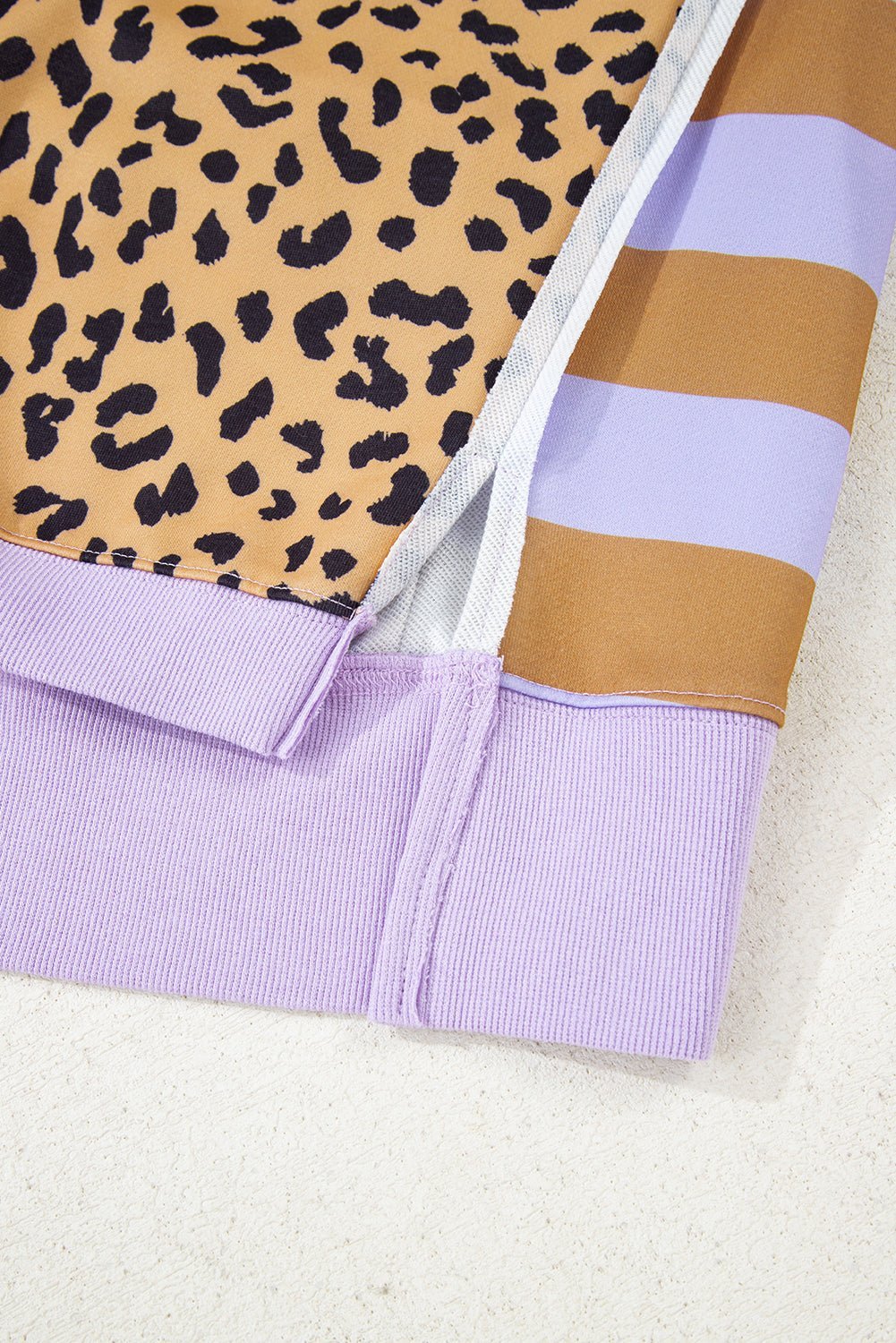 Close-up of a fabric with leopard print, stripes, and solid color on a light background