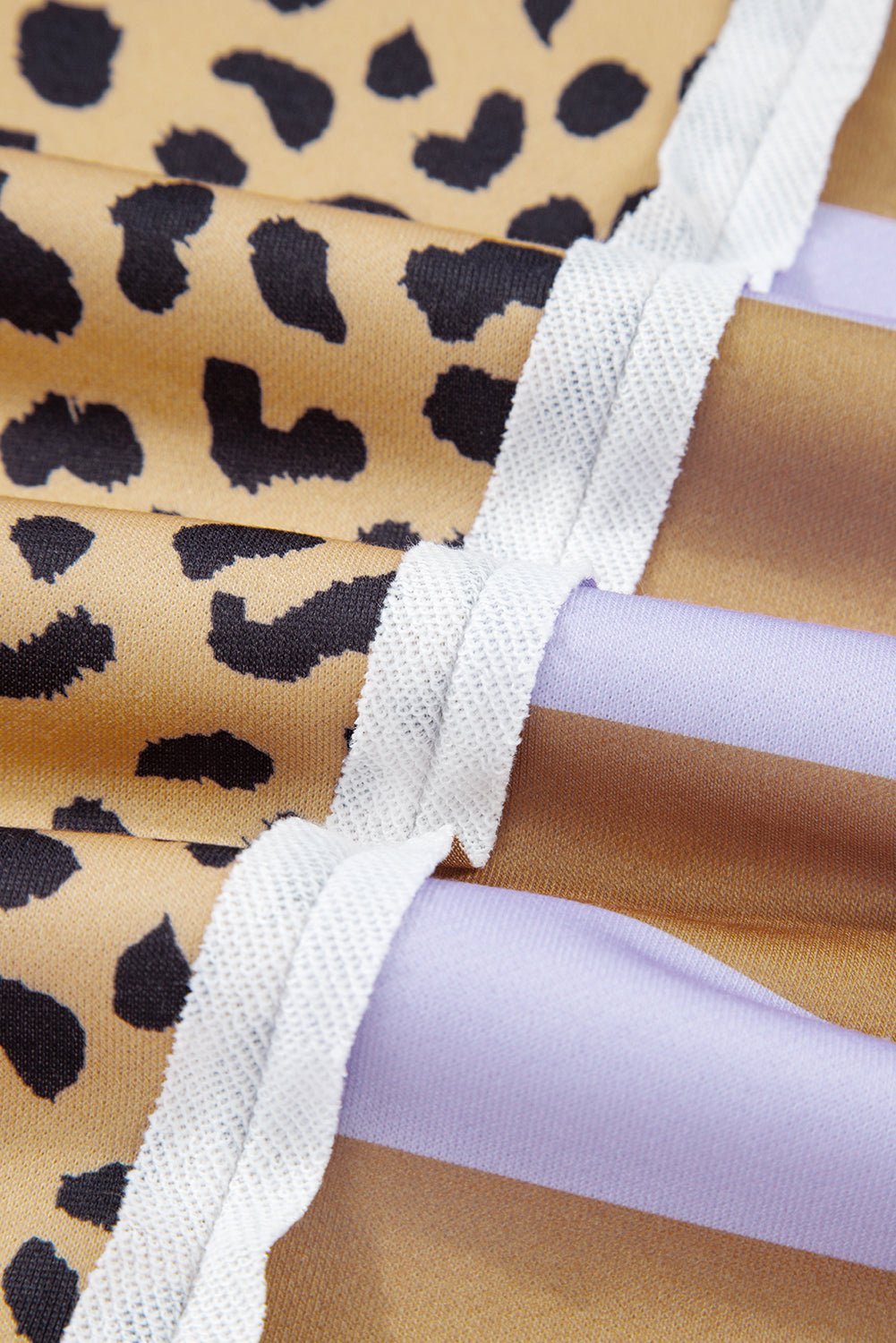 Close-up of a leopard print fabric with a white strap and purple material.