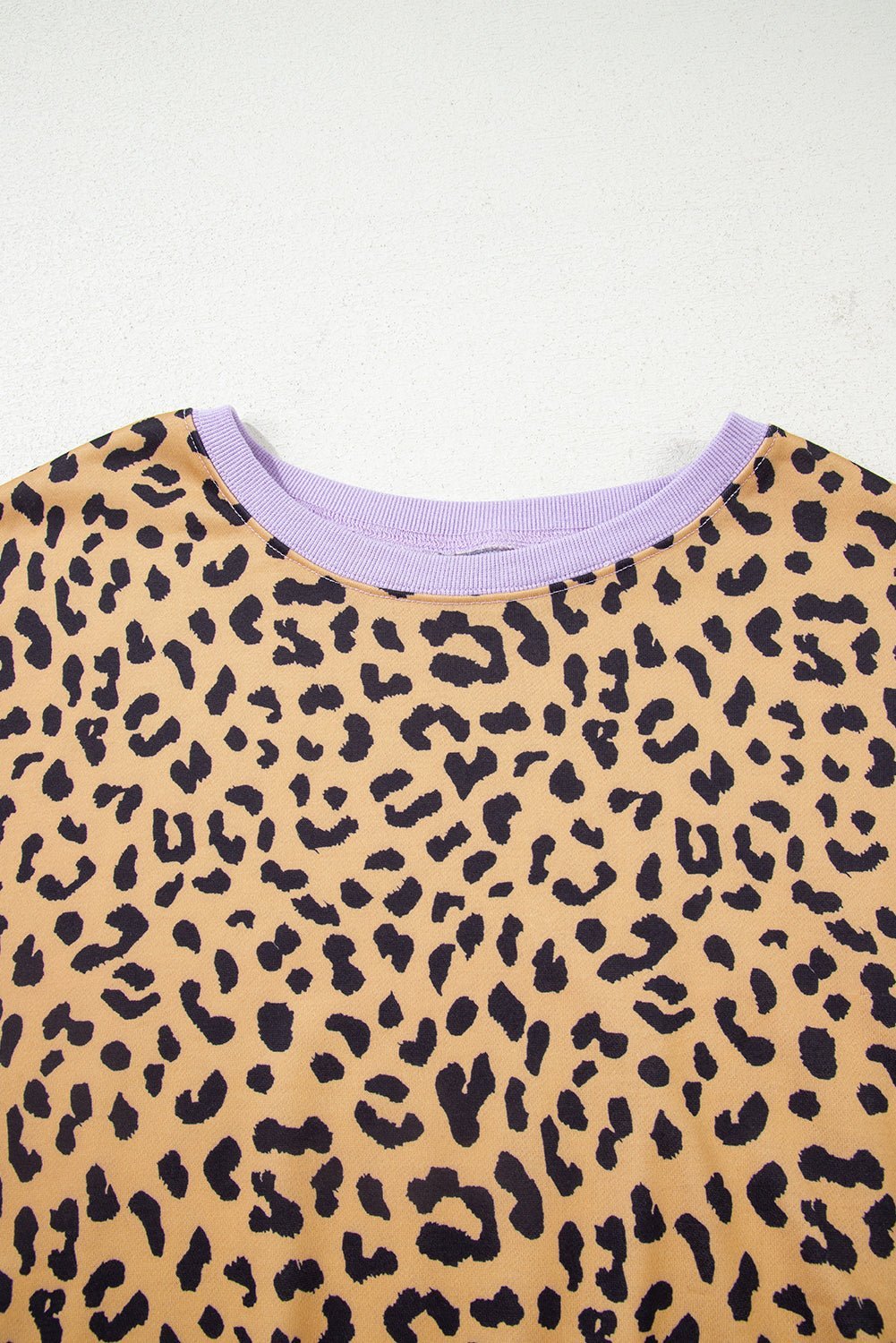 Leopard print top with a purple trim on a white background