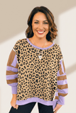 Woman wearing a leopard print top with purple and brown sleeves against a neutral background