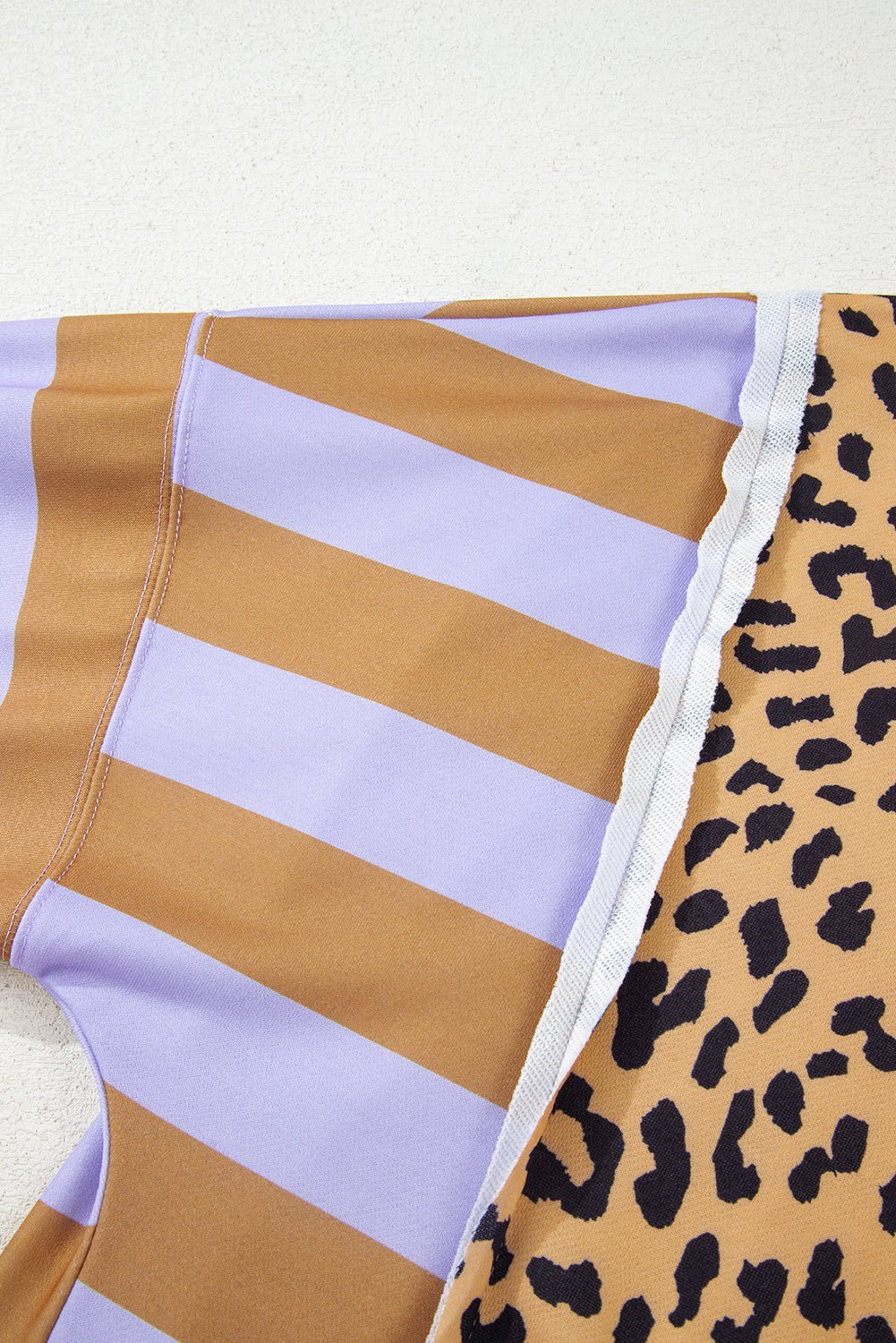 Close-up of a swimsuit with striped and leopard print patterns on a white background