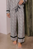 Person wearing beige, brown, and black animal-print pajamas with black trim.