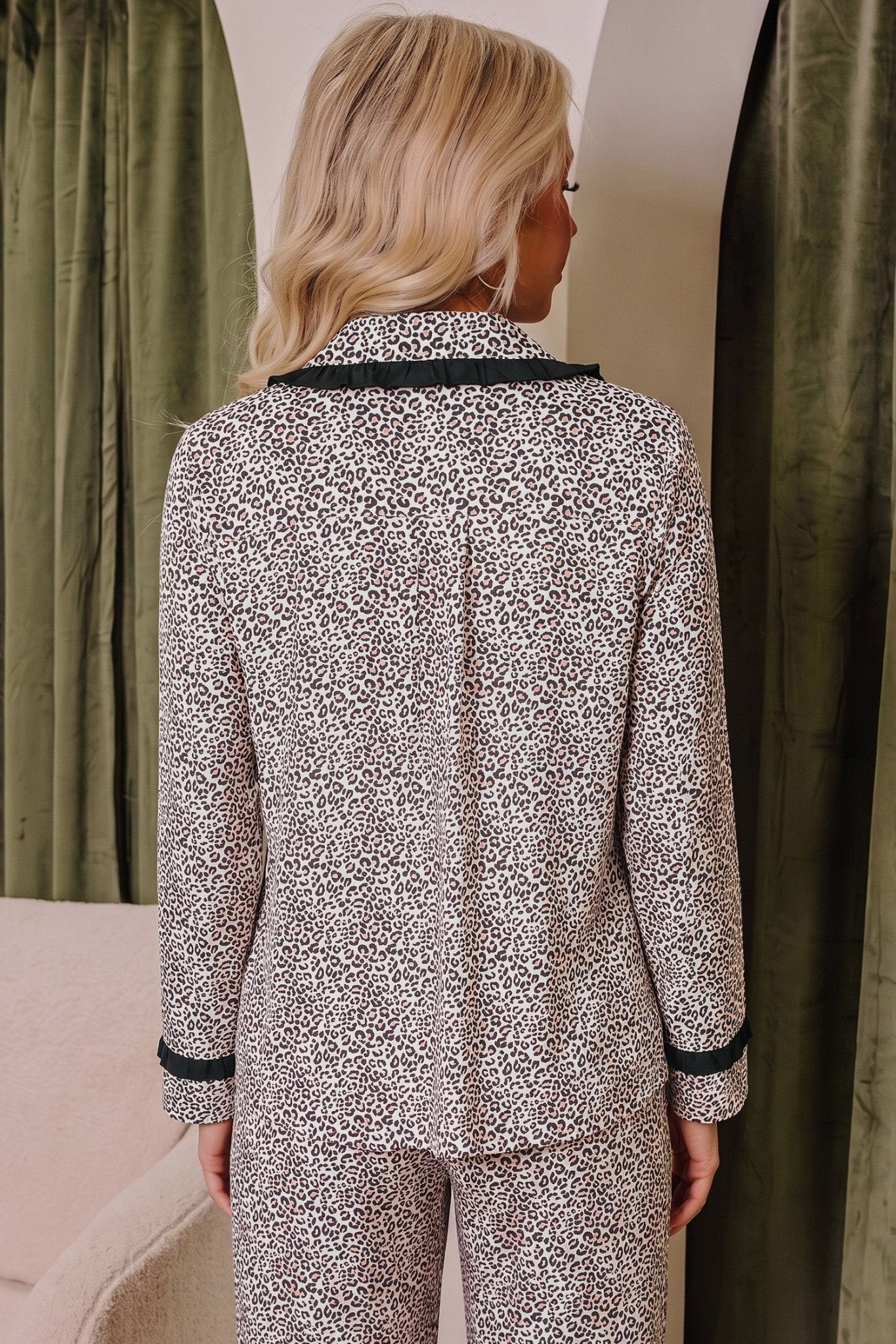 Woman wearing a beige, black, and white abstract-print pajama set.