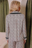 Woman wearing a beige, black, and white abstract-print pajama set.