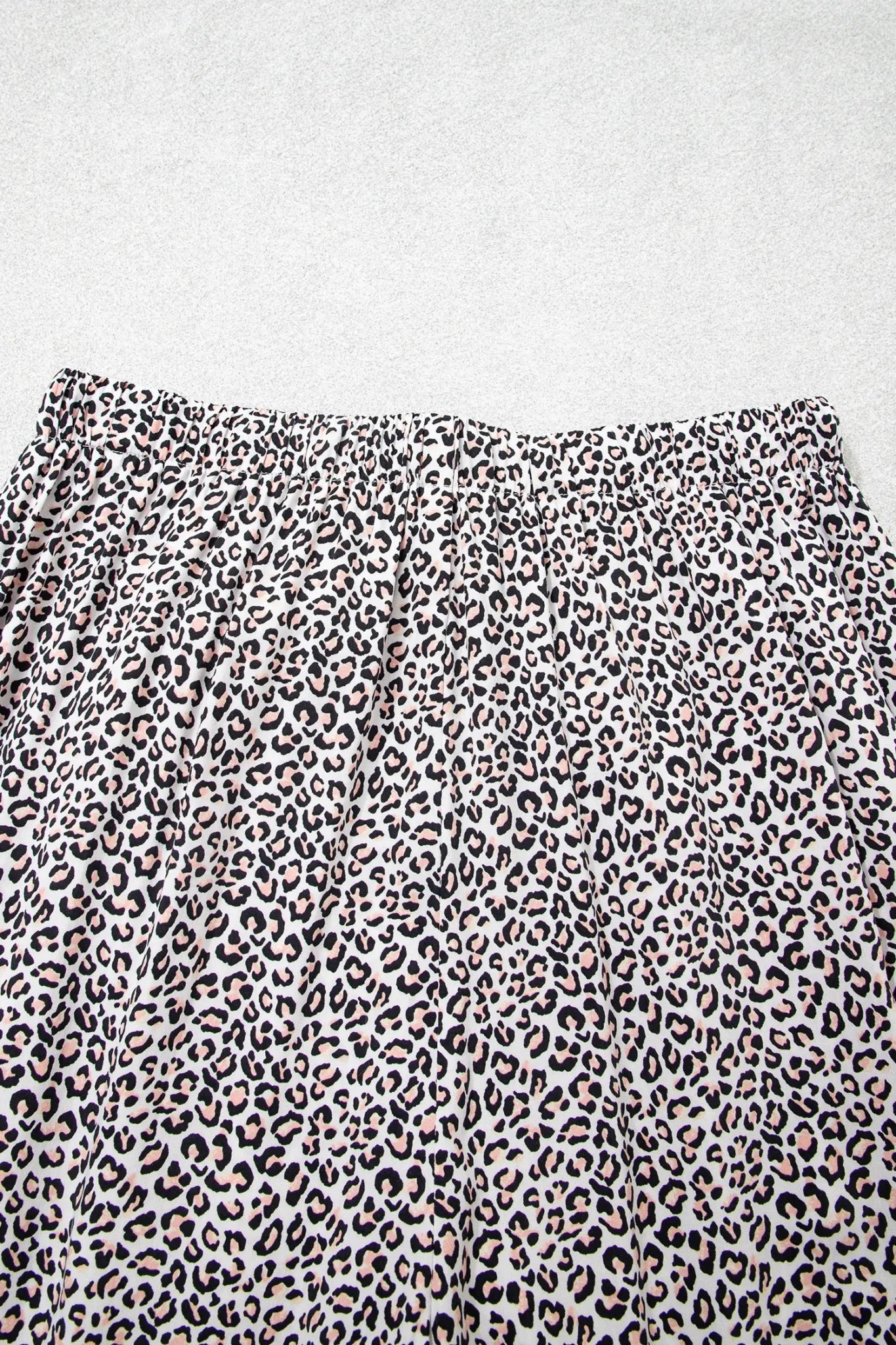 Close-up of a leopard print fabric with a black, brown, and beige animal pattern