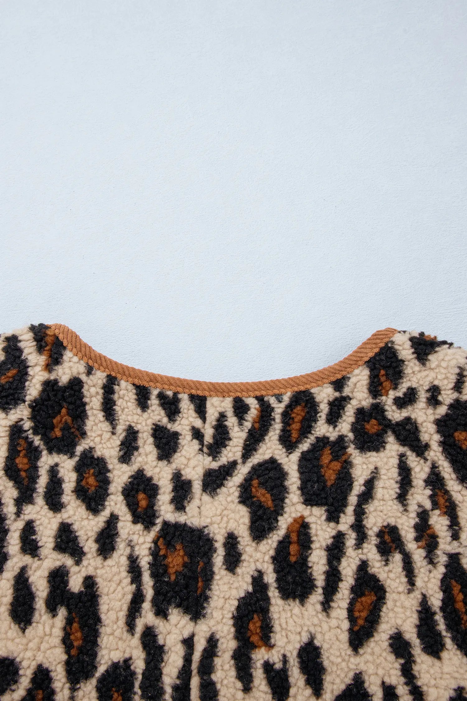 Close-up of corduroy trimmed back neckline on leopard sherpa jacket