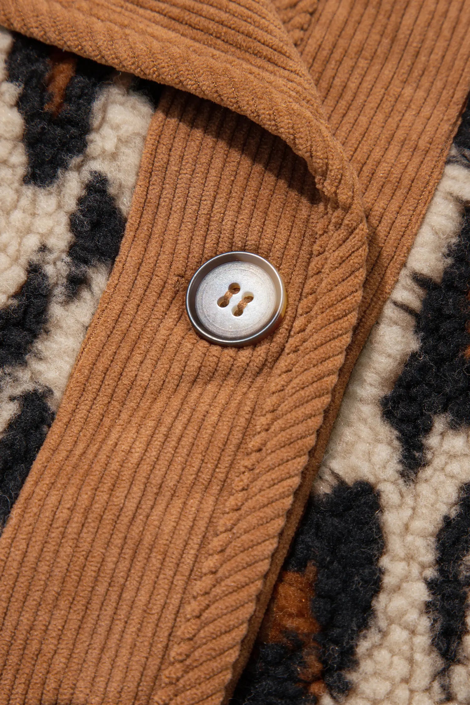 Close-up of button and camel corduroy placket on leopard sherpa jacket