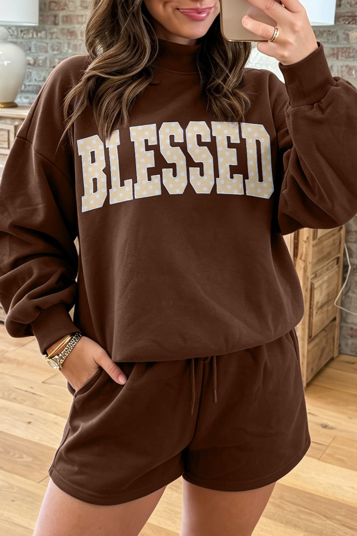 Woman in coffee BLESSED letter patch sweatshirt and shorts set, mirror selfie